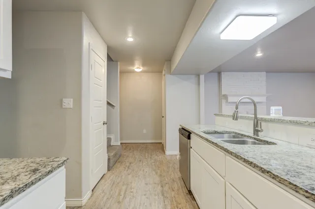 a kitchen with granite countertop a stove and a sink