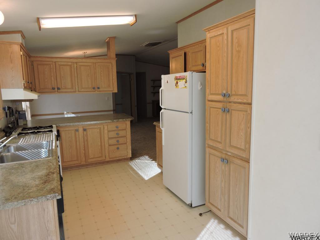 4053 Cove Road Golden Valley, AZ 86413 - Photo 10 of 20 a kitchen with a refrigerator sink stove and cabinets