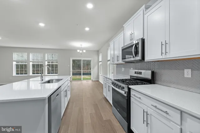 a large kitchen with stainless steel appliances granite countertop a lot of counter space and a sink