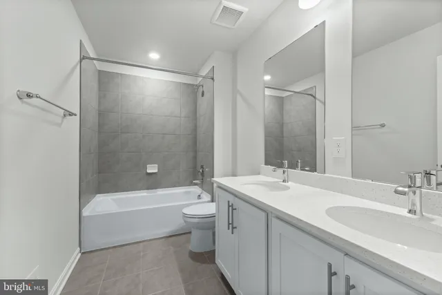 a bathroom with a bathtub shower sink mirror vanity and toilet