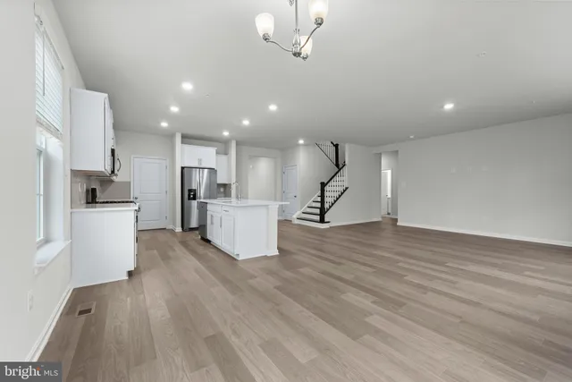 a view of a kitchen with a sink a refrigerator and a stove top oven