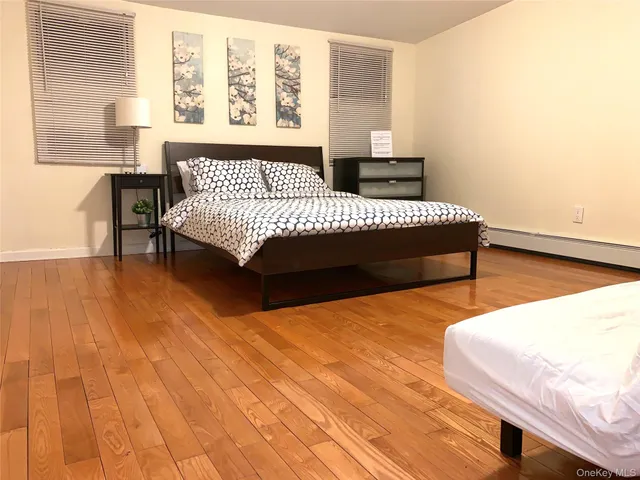 a bedroom with a bed lamp and a large window