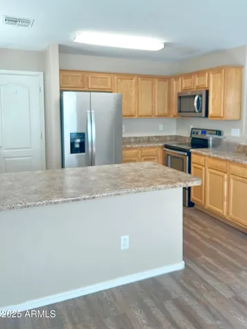 a kitchen with stainless steel appliances granite countertop a stove a sink and a refrigerator