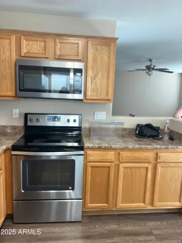 a kitchen with granite countertop a stove and a microwave