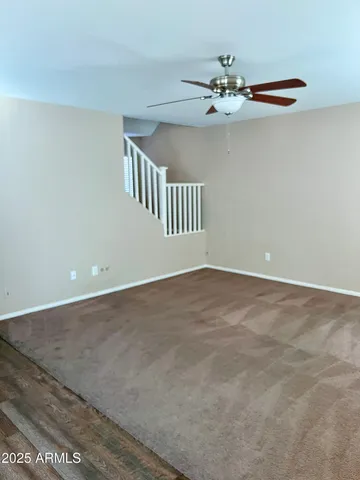 a view of a room with a ceiling fan and window