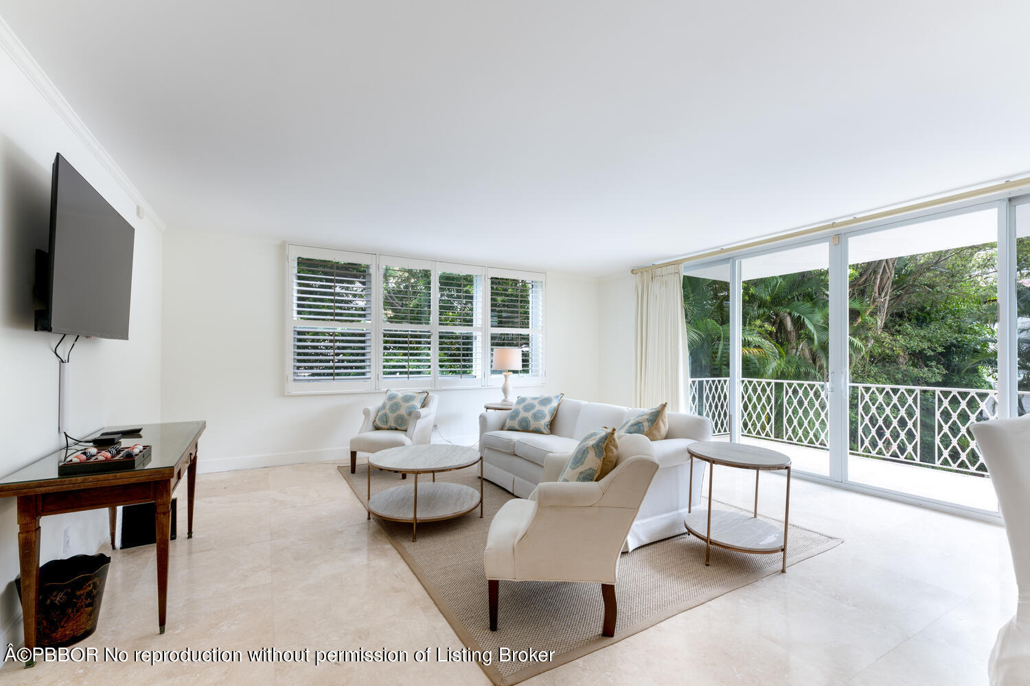 434 Chilean Avenue, Unit 2D Palm Beach, FL 33480 - Photo 3 of 19 a living room with furniture a flat screen tv and a floor to ceiling window