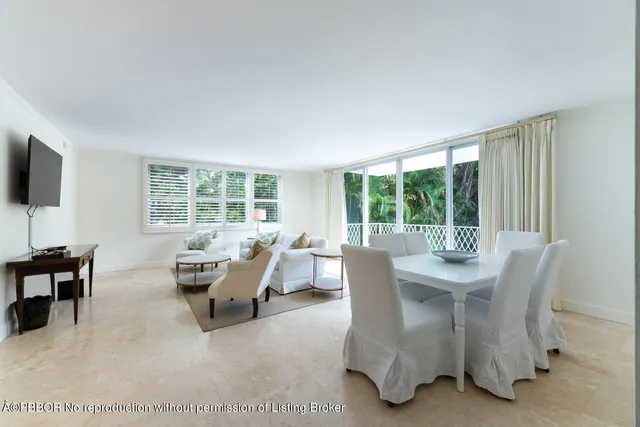 a dining room with furniture and a large window
