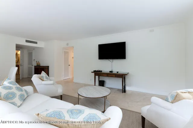 a living room with furniture a flat screen tv and a window