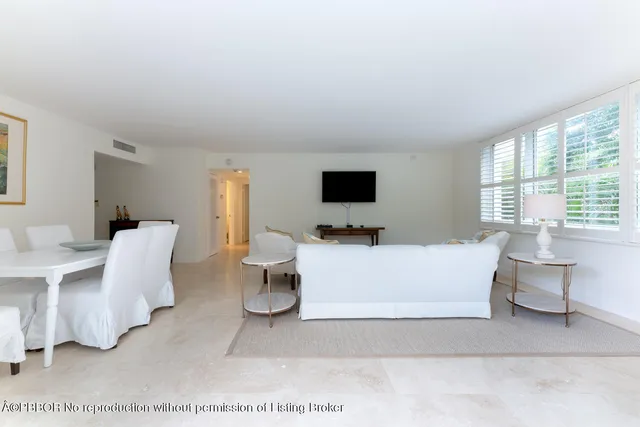 a living room with furniture a flat screen tv and a large window