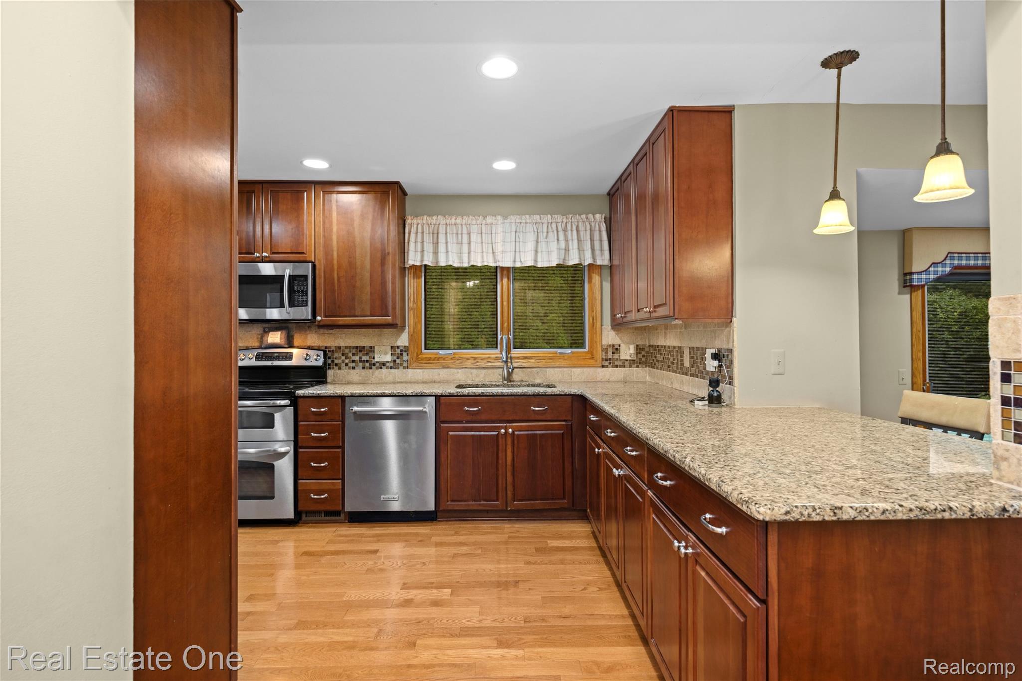 39750 Cheviot Road Canton, MI 48188 - Photo 23 of 71 Kitchen featuring wood cabinetry, stainless steel appliances, speckled countertops, and wood-finish flooring