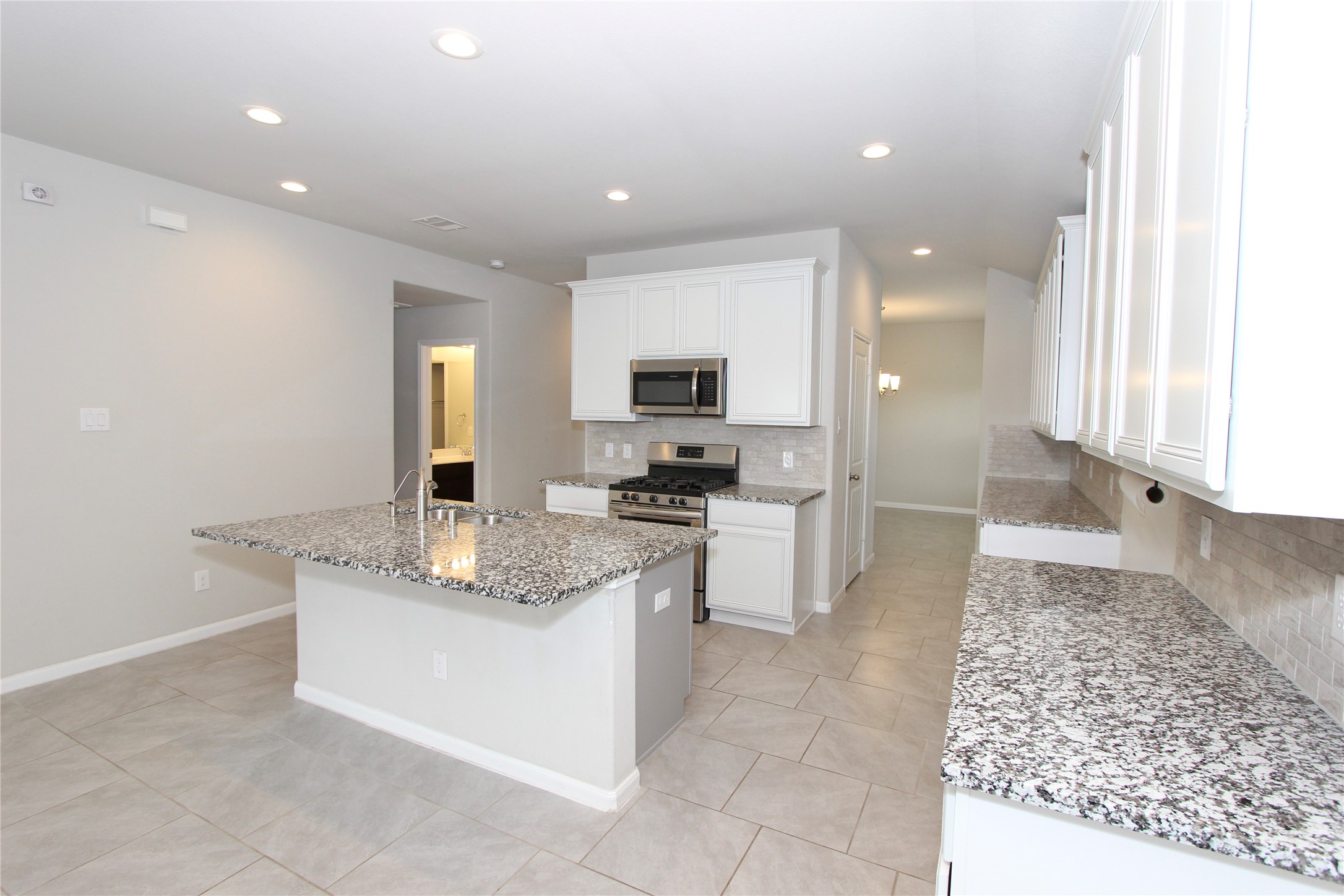 1303 Keaton Court Rosenberg, TX 77469 - Photo 5 of 22 a large kitchen with granite countertop a sink and a stove top oven with wooden floor