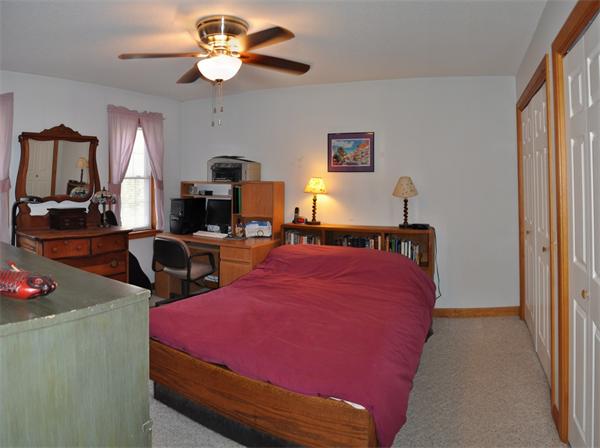 25 Shattuck Road Hadley, MA 01035 - Photo 16 of 26 a bed room with a bed mirror and a chandelier