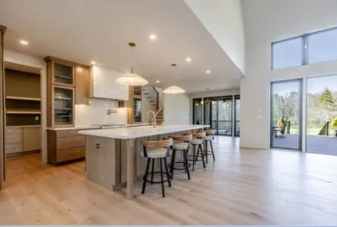 a kitchen with stainless steel appliances kitchen island granite countertop a table chairs sink and cabinets