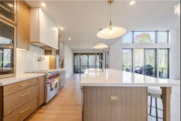 a kitchen with kitchen island granite countertop a stove and a sink