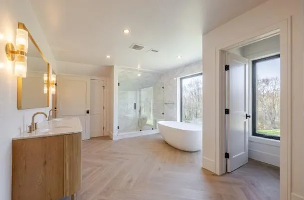 a bathroom with a tub sink and mirror