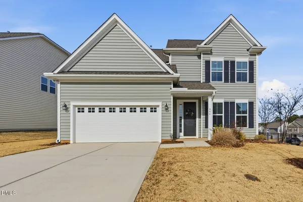 a view of a house with a yard and garage