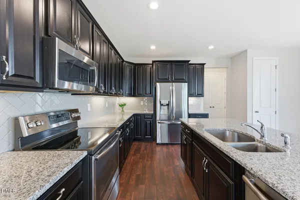 a kitchen with stainless steel appliances granite countertop a sink stove and refrigerator