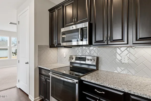 a kitchen with granite countertop cabinets stainless steel appliances and wooden cabinets