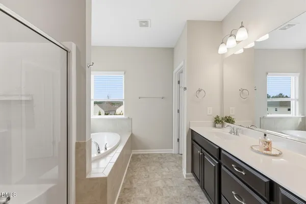 a en suite bathroom with a granite countertop sink a toilet a mirror and shower