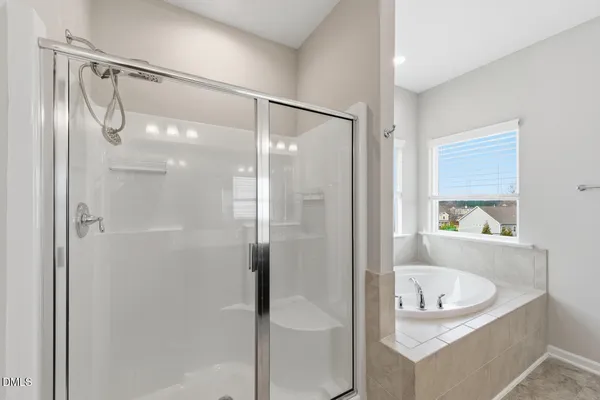 a bathroom with a granite countertop bathtub shower sink mirror and toilet