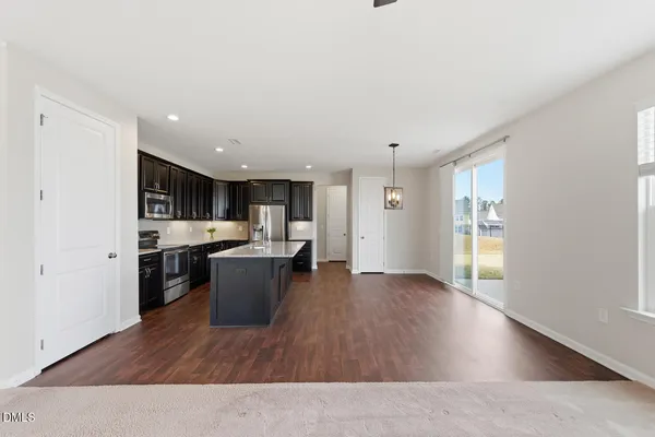 a kitchen with a wooden floor and a living room