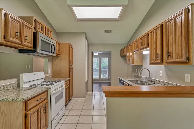 a kitchen with stainless steel appliances granite countertop a sink stove and cabinets