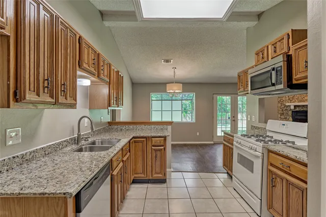 a kitchen with stainless steel appliances granite countertop a sink stove and cabinets