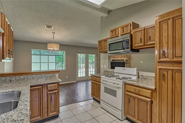 a kitchen with stainless steel appliances granite countertop a stove microwave and cabinets