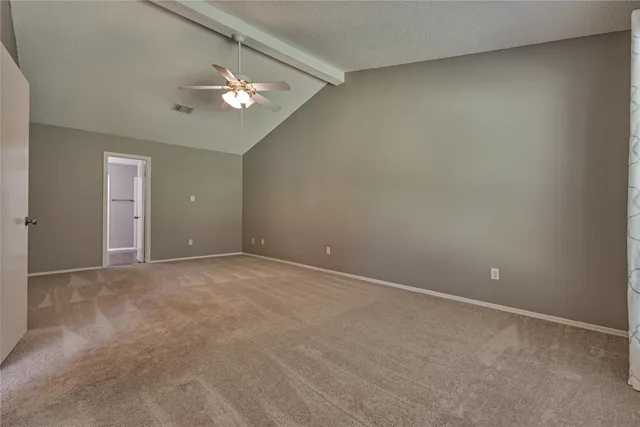 a view of an empty room with a chandelier fan