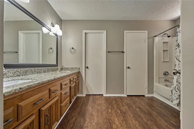 a bathroom with a granite countertop sink a mirror a shower and a bathtub