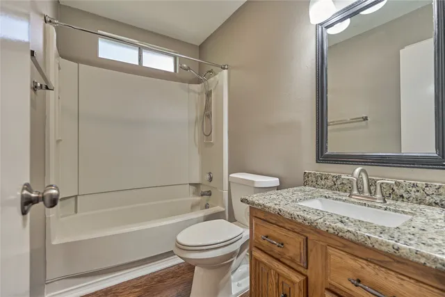 a bathroom with a granite countertop sink toilet and shower