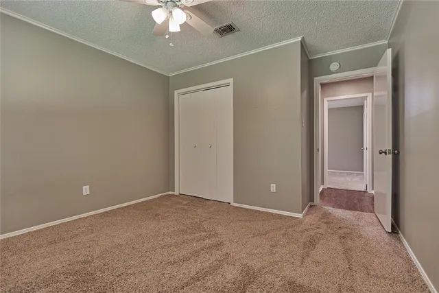 a view of an empty room with a chandelier fan