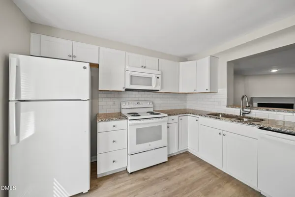 a kitchen with cabinets appliances a sink and a refrigerator