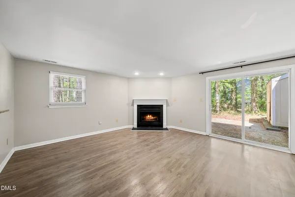 an empty room with large windows and a fireplace