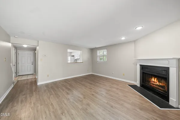 a view of an empty room with a fireplace and a window