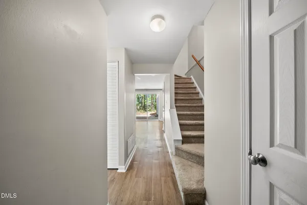 a view of a hallway with wooden floor and staircase