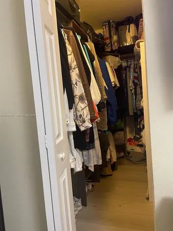 a view of walk in closet with clothes and shoes