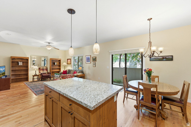7235 Viansa Court Midvale, UT 84047 - Photo 43 of 43 Kitchen featuring a kitchen island, wood finish cabinetry, light wood-style floors, and open floor plan