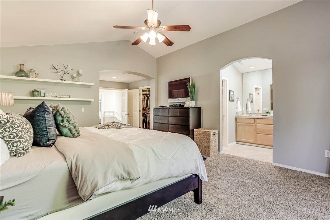 4331 147th Place Southeast Bothell, WA 98012 - Photo 22 of 33 a bedroom with a large bed a chandelier and dresser