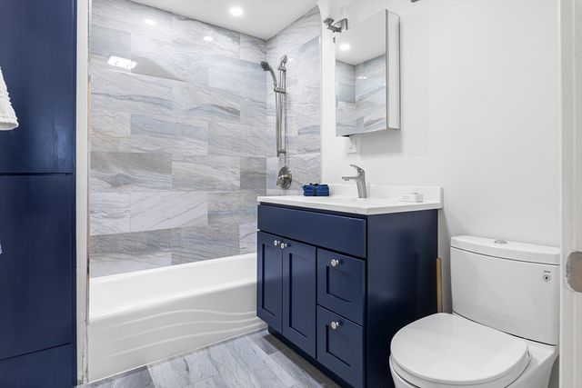 a bathroom with a sink vanity mirror and toilet