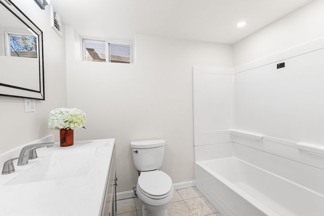 a white toilet sitting next to a bathroom sink and tub