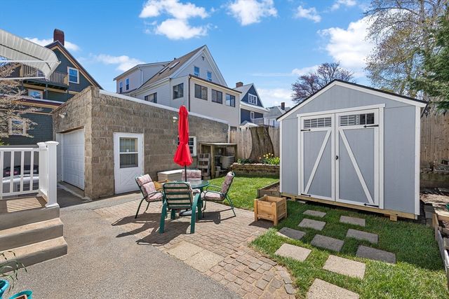 a view of a patio with table and chairs and a barbeque