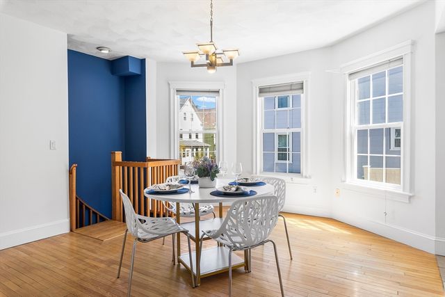 a dining room with furniture a chandelier and wooden floor