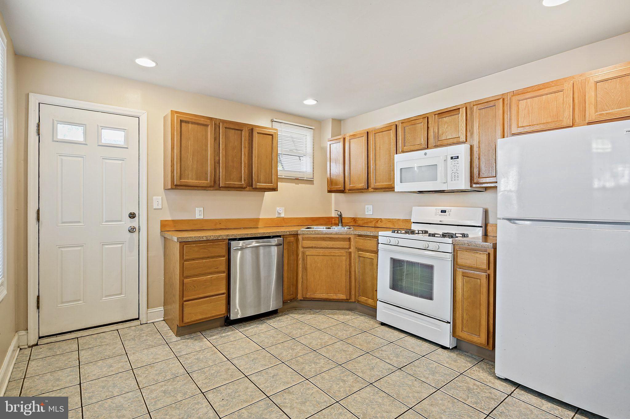 211 North Streeper Street Baltimore, MD 21224 - Photo 11 of 33 a kitchen with a stove sink and a refrigerator