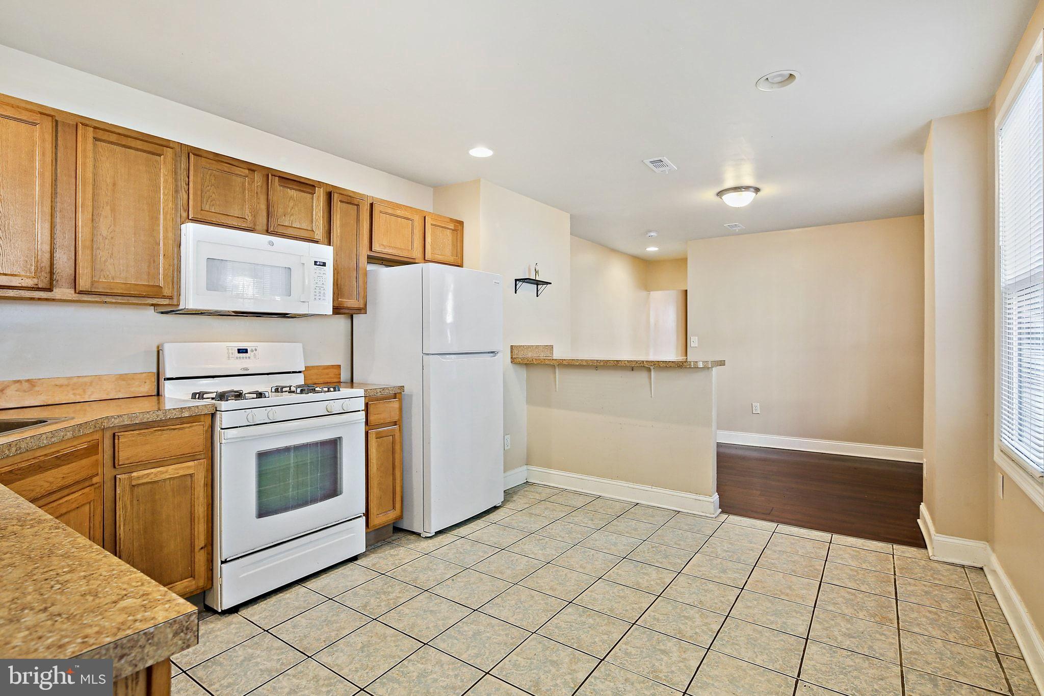 211 North Streeper Street Baltimore, MD 21224 - Photo 12 of 33 a kitchen with white cabinets and white appliances