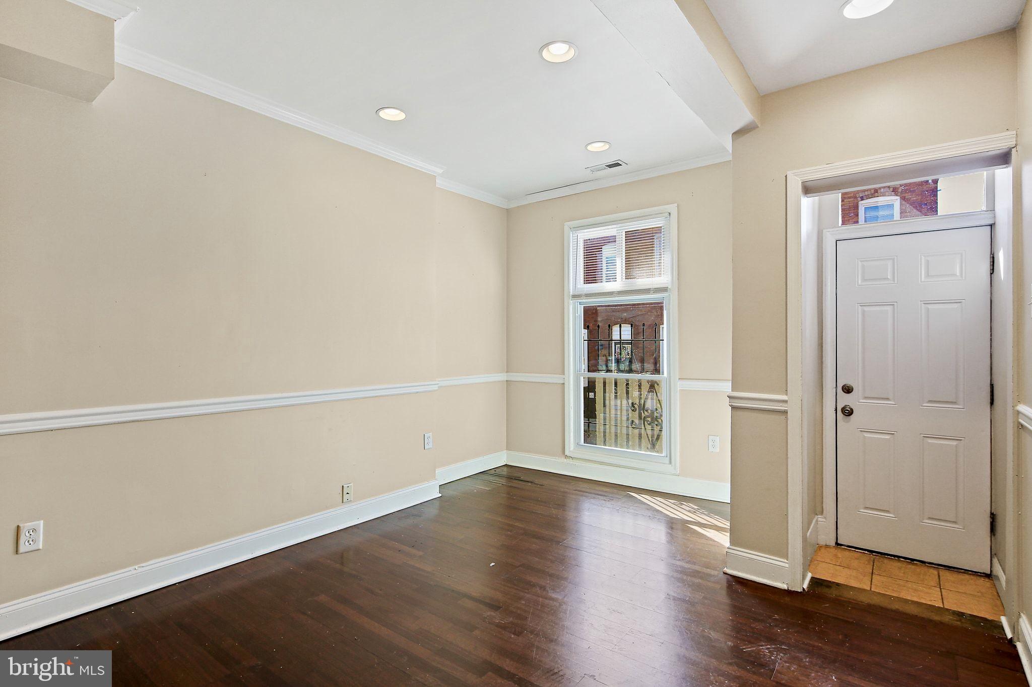 211 North Streeper Street Baltimore, MD 21224 - Photo 4 of 33 an empty room with wooden floor and windows