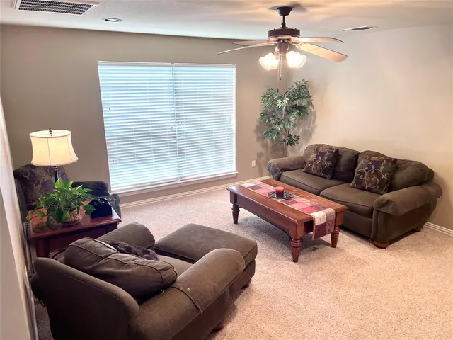 a living room with furniture a large window and a chandelier