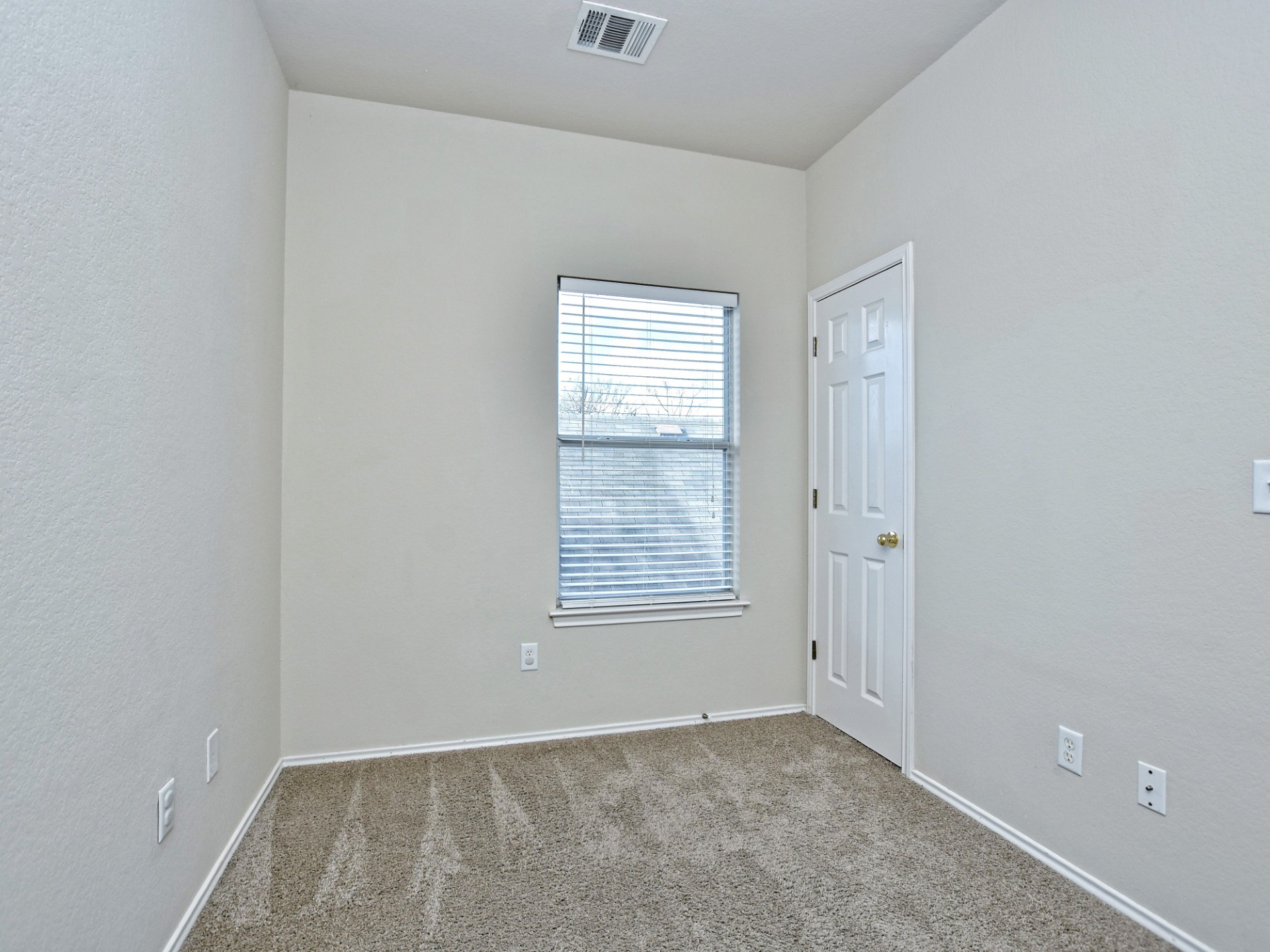 917 East 3rd Street Georgetown, TX 78626 - Photo 16 of 23 A well-lit bedroom offering a blank canvas for personalization with carpeted floors and a single window.