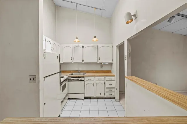 a kitchen with white cabinets and white appliances