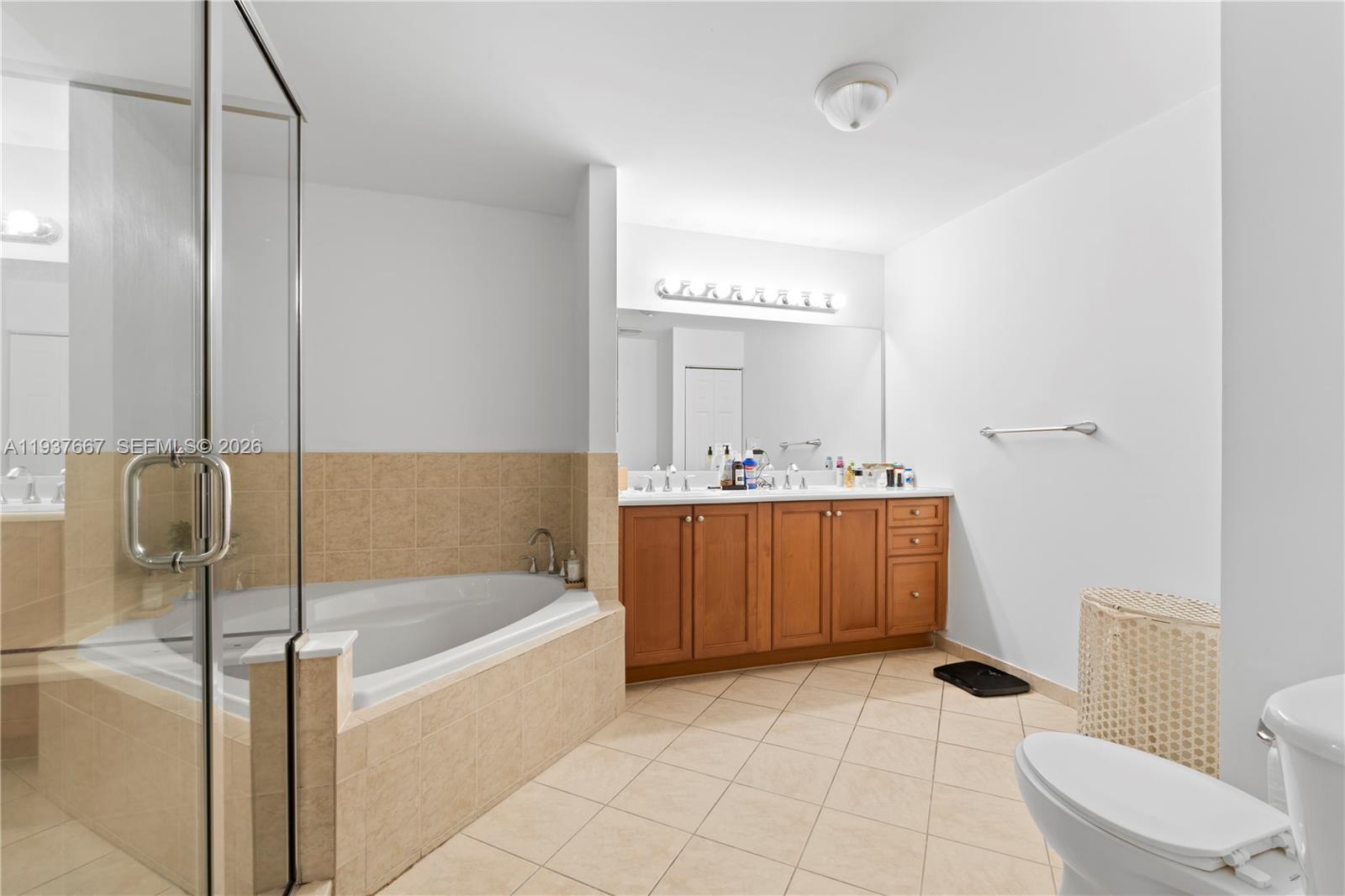 8395 Southwest 73rd Avenue, Unit 115 Miami, FL 33143 - Photo 17 of 26 a bathroom with a bathtub sink mirror and toilet